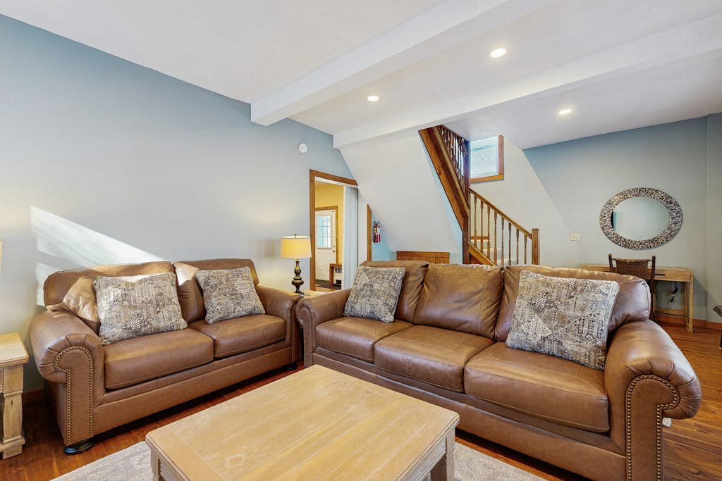 Living room with leather sofas and staircase