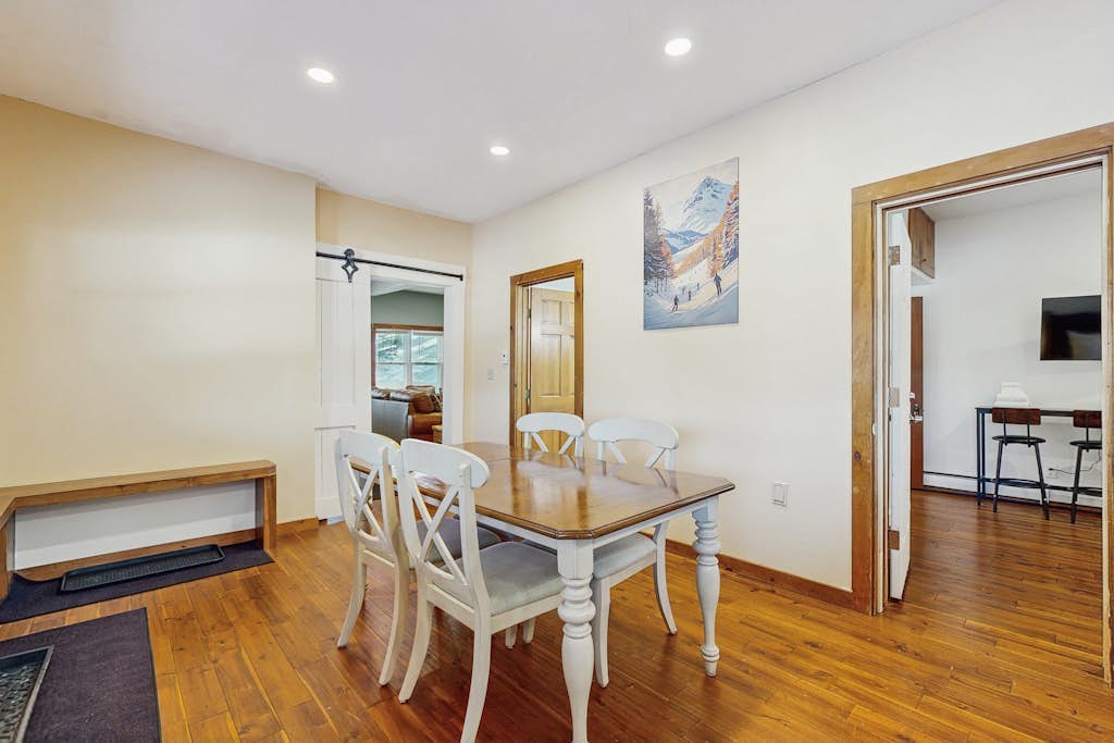 Dining room with barn door and Vermont ski art