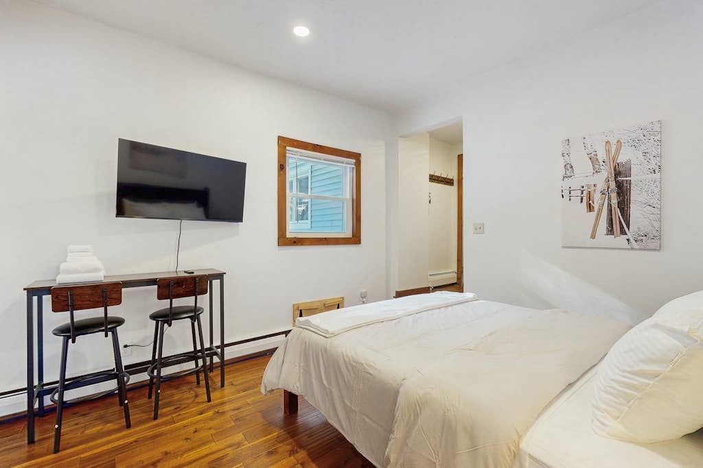 Bedroom with wall-mounted TV and desk