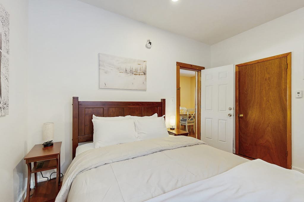 Bedroom with wood headboard and mountain art