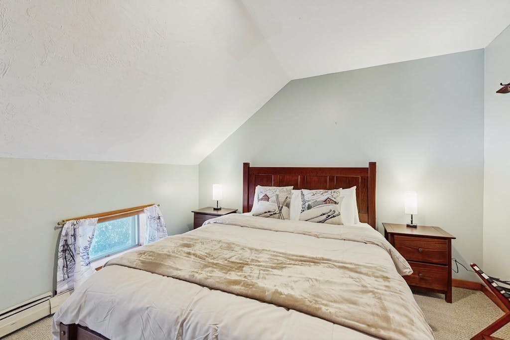 Vaulted bedroom with queen bed and ski-themed pillows