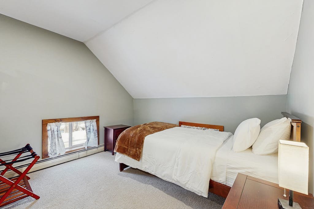 Bright bedroom with queen bed under a vaulted ceiling